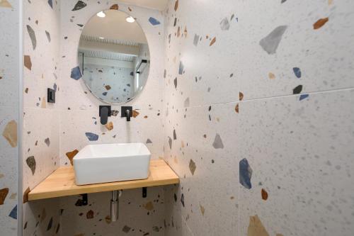 ein Badezimmer mit einer Felswand mit einem Spiegel und einem Waschbecken in der Unterkunft Garden of Eden in Kalamaki