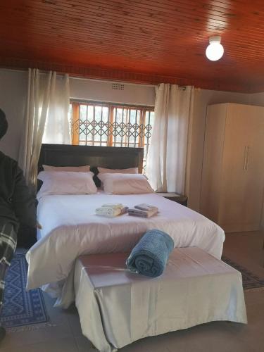 - une chambre avec 2 lits avec des draps blancs et une fenêtre dans l'établissement Nakhah Guesthouse - Private Exterior, à Witbank