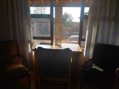 une chambre avec une table, deux chaises et une fenêtre dans l'établissement Nakhah Guesthouse - Private Exterior, à Witbank