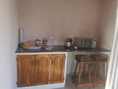 - une cuisine avec un comptoir et un four micro-ondes dans l'établissement Nakhah Guesthouse - Private Exterior, à Witbank
