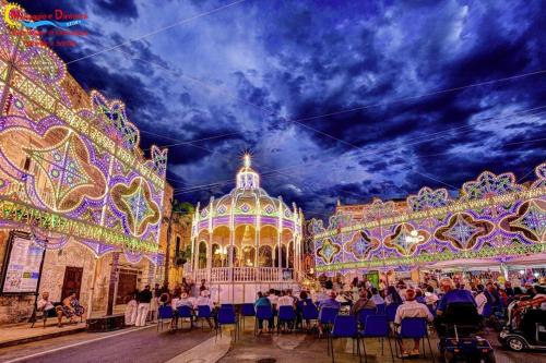 un grupo de personas sentadas en sillas frente de un carnaval en Da Zia Betty casa vacanza, en Maruggio