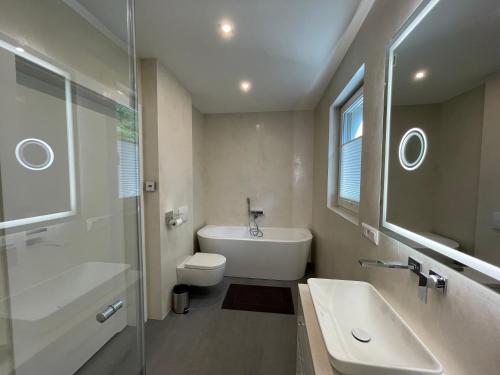 La salle de bains est pourvue d'un lavabo, de toilettes et d'une douche. dans l'établissement Luxuriöses Ferienhaus nähe Kattowitz, à Tarnowskie Góry