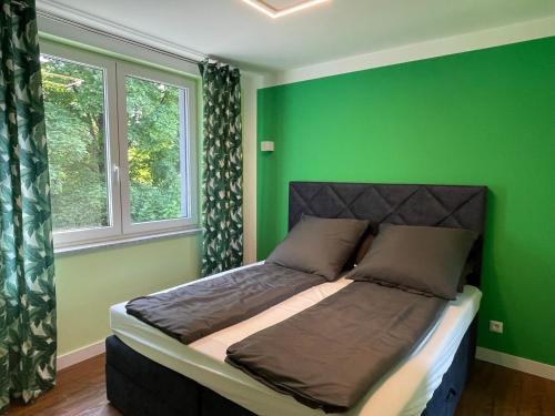 een slaapkamer met groene muren en een bed in een kamer bij Luxuriöses Ferienhaus nähe Kattowitz in Tarnowskie Góry