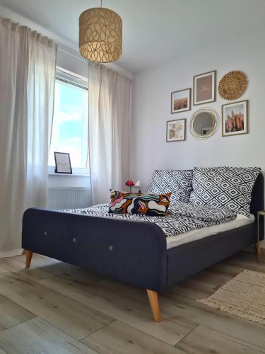 a large bed in a room with a window at Przystań Natura Apartamenty nad rzeką, cisza i rowery in Iława