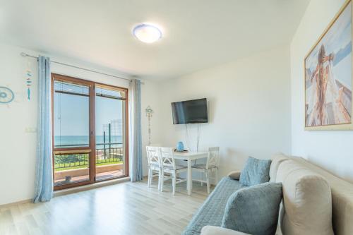 uma sala de estar com um sofá e uma mesa com uma televisão em Apartment Poemia, complex Carpe Diem, private pool and free parking em Balchik