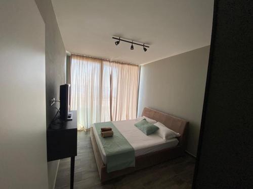 a small bedroom with a bed and a window at Private Villa at Olea Luxury Resort in Dhërmi