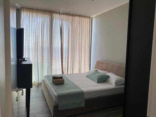 a bedroom with a bed and a large window at Private Villa at Olea Luxury Resort in Dhërmi