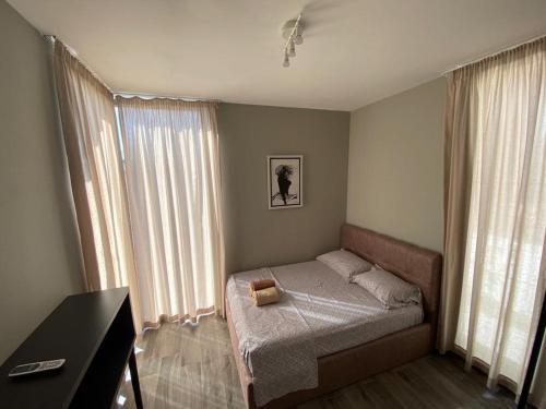 a bedroom with a bed and a desk and windows at Private Villa at Olea Luxury Resort in Dhërmi