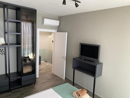 a living room with a tv on a desk with a television at Private Villa at Olea Luxury Resort in Dhërmi