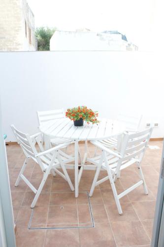 a white table and chairs on a patio at Le Casette a Favignana in Favignana