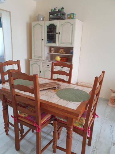une cuisine avec une table et des chaises en bois dans l'établissement CHEZ PILOU, à Varennes-sur-Allier