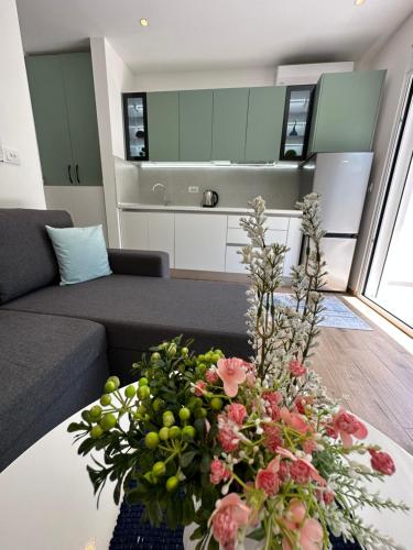 una sala de estar con una mesa con flores. en Rita Villas, en Ulcinj