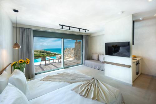 a bedroom with a white bed and a large window at Dedalos Touch Boutique Hotel in Skaleta