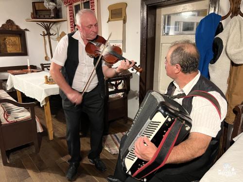 a man playing a violin next to a man playing a accordion at Transylvania Apartments in Borzont