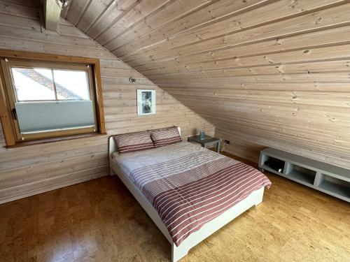 ein Schlafzimmer mit einem Bett in einer Holzhütte in der Unterkunft FeWo Wardersee 