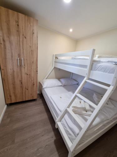 a bedroom with two bunk beds and a wooden cabinet at Mobile home Sofija in Drage