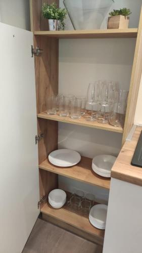 a cupboard filled with glasses and plates and bowls at Mobile home Sofija in Drage