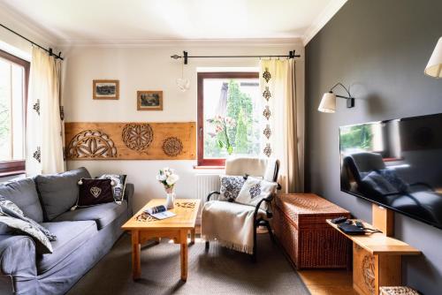 a living room with a couch and a table at Apartamenty Niebanalne - Blisko Krupówek in Zakopane