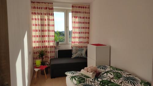 una pequeña sala de estar con cama y ventana en Sky View, en Varsovia