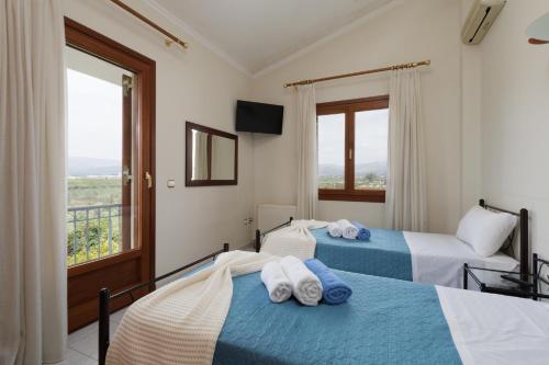 two beds in a room with a balcony at Villa Ero in Argos