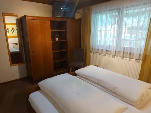 een slaapkamer met een bed, een raam en een kast bij Haus Fischer in Pettneu am Arlberg