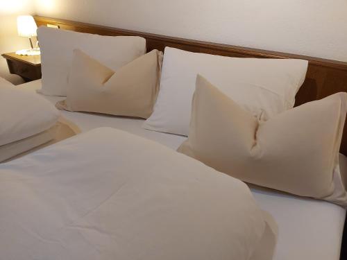 a bed with white pillows and a head board at Haus Fischer in Pettneu am Arlberg