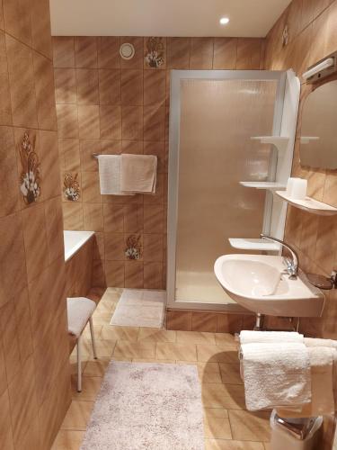 y baño con lavabo, ducha y espejo. en Haus Fischer, en Pettneu am Arlberg