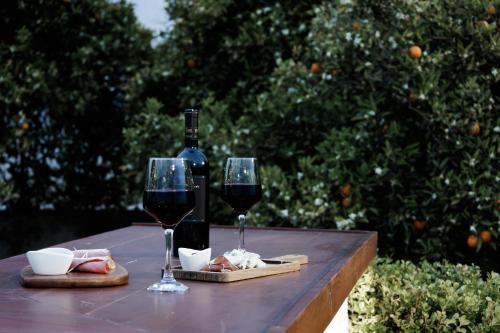 two glasses of red wine sitting on a wooden table at Villa Ero in Argos