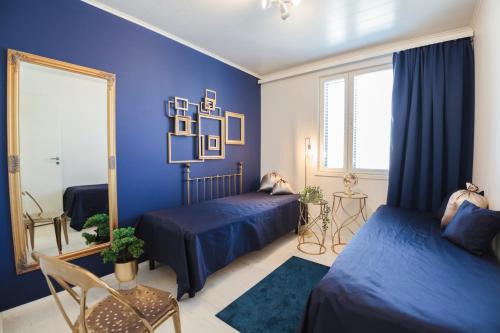 1 dormitorio azul con 2 camas y espejo en Apartment Tuomenkartano C4 iso huoneisto saunalla Kalajoki, en Kalajoki