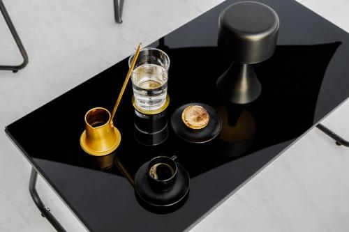 a black table with a glass of water and other items at Villa Ero in Argos
