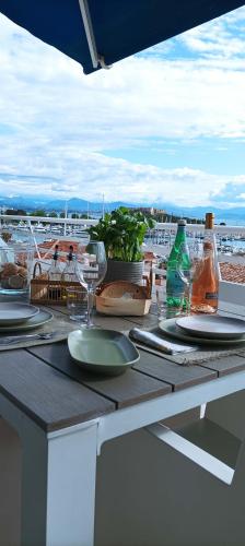 une table avec des assiettes et des verres à vin sur un balcon dans l'établissement Penthouse with extraordinary view, à Antibes