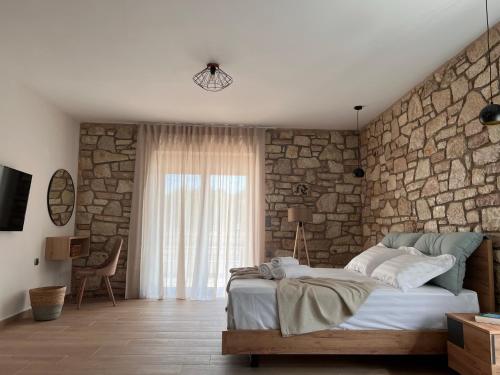 a bedroom with a stone wall and a bed at Michelangelo suites and apartments in Valanidorachi