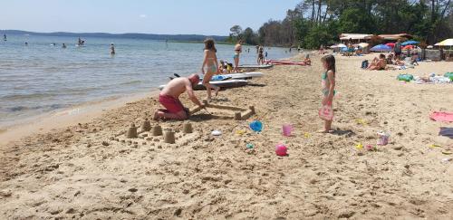 a woman building a sand castle on a beach at Chambres Du Petit Bonheur in Biscarrosse
