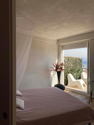 une chambre avec un lit et une grande fenêtre dans l'établissement Penthouse with extraordinary view, à Antibes
