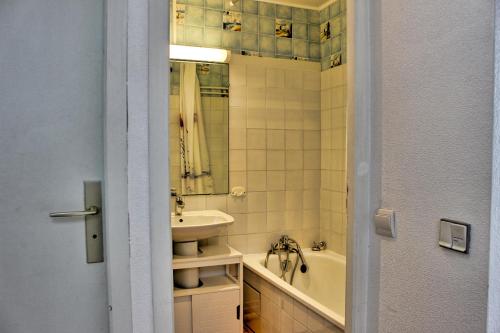 La salle de bains est pourvue d'un lavabo, de toilettes et d'une baignoire. dans l'établissement Les Ondines 21 YourHostHelper, à Saint-Georges-de-Didonne