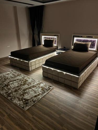 twee bedden in een slaapkamer met twee tapijten op de vloer bij مكتب Vib للسياحه لي خدمه راجل الأعمال in Caïro