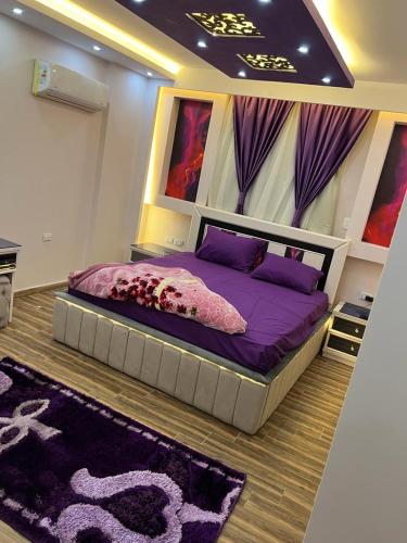een slaapkamer met een bed met paarse lakens en paarse kussens bij مكتب Vib للسياحه لي خدمه راجل الأعمال in Caïro