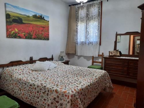 een slaapkamer met een bed, een ladekast en een spiegel bij La Cantinetta di Barberino in Greve in Chianti