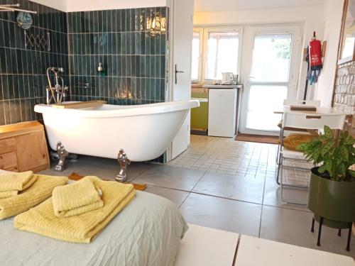 een badkamer met een bad, een wastafel en een bed bij Squat Deluxe Berlin, the hostel in Berlijn