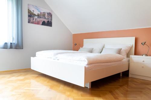 ein Schlafzimmer mit einem großen weißen Bett in einem Zimmer in der Unterkunft B&B Gösselsdorfer Seeblick in Sittersdorf