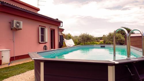 a swimming pool in the backyard of a house at PM Villa Arenosu Guest House in Fertilia