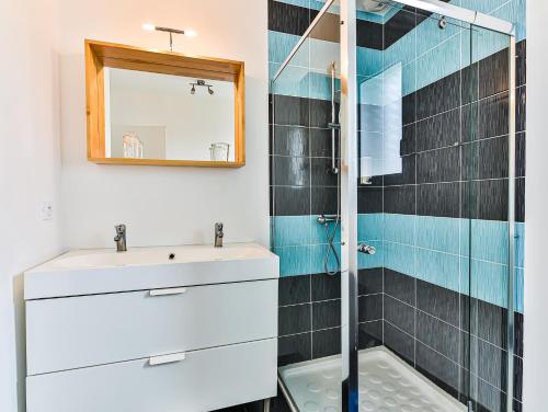 La salle de bains est pourvue d'un lavabo et d'une douche. dans l'établissement Au Logis de la Treille, à La Barre-de-Monts
