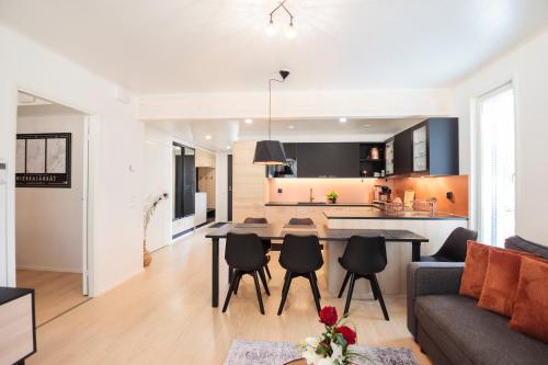 a living room and kitchen with a table and chairs at Apartment Tuomenkartano B1 iso huoneisto saunalla Kalajoki in Kalajoki