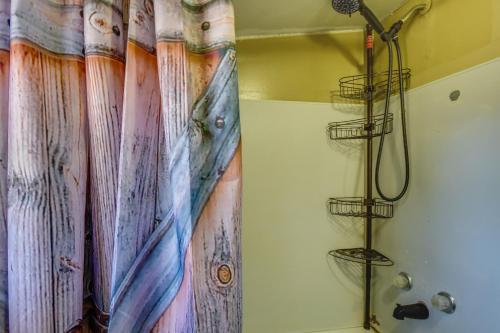 y baño con ducha y cortina de ducha. en Cozy Cabin Near Lake Hartwell and Clemson University, en Anderson