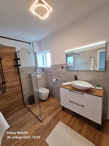 een badkamer met een wastafel, een douche en een toilet bij Penthouse Seaview in Trogir