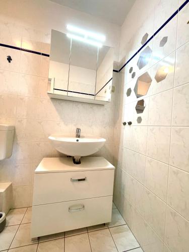 a white bathroom with a sink and a mirror at Sonnendeck 3 in Zingst