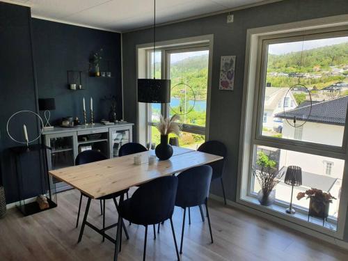 a dining room with a wooden table and chairs at Nydelig leilighet- Solrik/2 balkonger in Seim