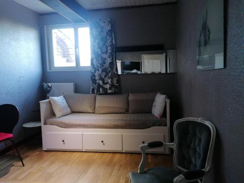a living room with a couch and a window at Charmant Appartement 10mn Rouen in Franqueville-Saint-Pierre