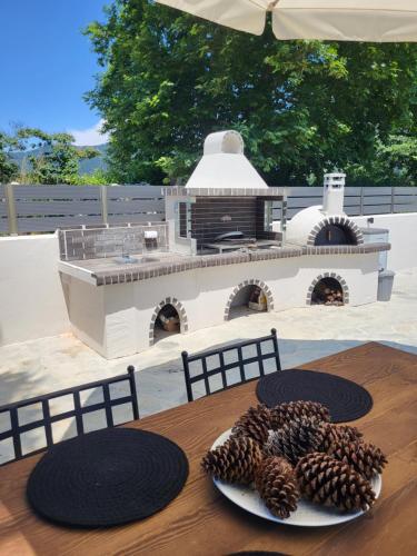 une table avec une plaque recouverte de cônes de pin dans l'établissement Casa O' - Moderne Villa mit großer Terrasse und privatem Swimmingpool, à Skala Potamias