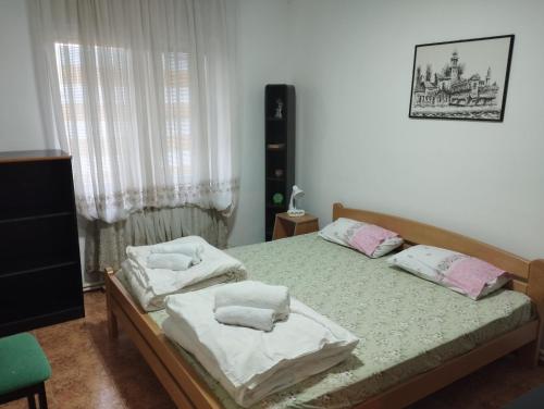 um quarto com 2 camas com almofadas brancas e cor-de-rosa em Apartment Angelina em Skopje